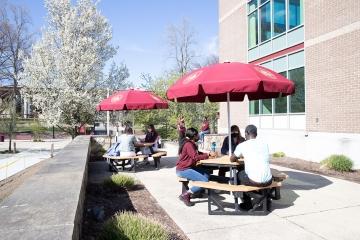 Students eating outside at picnic tables outside Donovan Dining Center