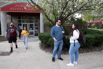 Students talking near and walking out of Donovan Dining Hall